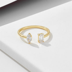 Gold ring with two diamonds on a white surface