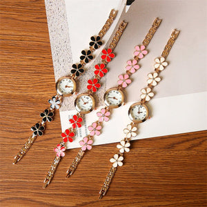 Set of floral-themed wristwatches on a wooden surface