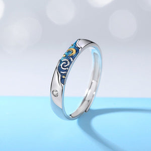 Silver ring with blue enamel starry night designs, white gold plating, and cubic zirconia accents, displayed on a blue background.