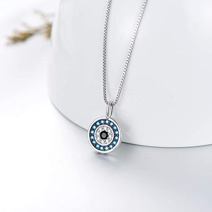 Silver necklace with a round pendant featuring blue and clear stones on a white background