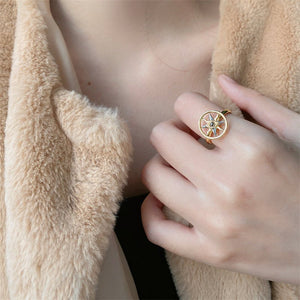 Women wearing a gold spinner ring with a evil eye compass design