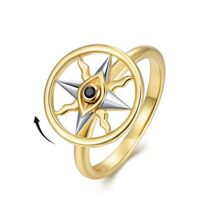 Gold spinner ring with a evil eye compass design on a white background