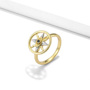Gold spinner ring with a evil eye compass design on a white background