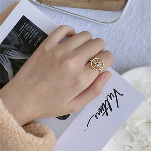 Women wearing a gold spinner ring with a evil eye compass design