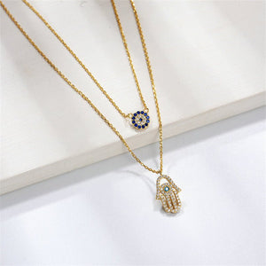 Two gold necklaces with eye-shaped pendants on a white background