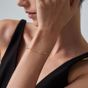 Close-up of a woman wearing a delicate bracelet on her wrist.