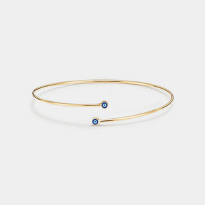 Gold bracelet with a blue gemstone on a white background