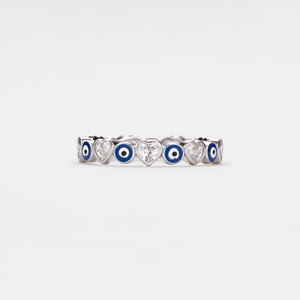 A white gold-plated sterling silver stacking ring with blue enamel evil eyes and heart-shaped cubic zirconia accents