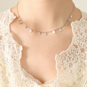 Silver necklace with heart-shaped pendants on a mannequin wearing a lace garment.
