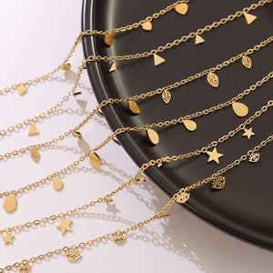 Gold necklaces with various charms on a black plate