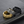 Three rings in gold, silver, and black on a textured dark surface