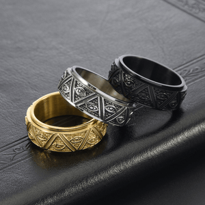 Three rings in gold, silver, and black on a textured dark surface