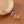 Three rings in gold, silver, and bronze on a brown surface with a beige plate.