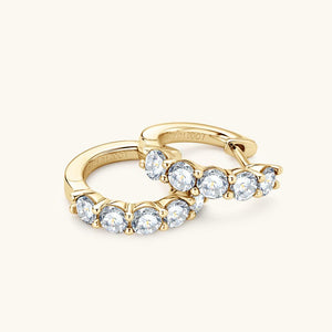 Gold earring with clear gemstones on a white background