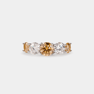 A five-stone color moissanite cocktail ring with alternating pink andlessen clear stones, set in a silver band with hypoallergenic plating.