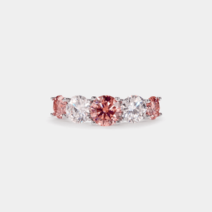 A five-stone color moissanite cocktail ring with alternating pink andlessen clear stones, set in a silver band with hypoallergenic plating.