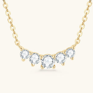 Gold necklace with clear gemstones on a white background