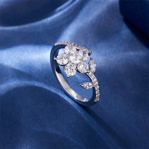 A gold-colored fidget spinner ring with a floral design, featuring white cubic zirconia stones.