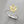 Silver ring with yellow gemstones on a gray background