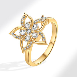 Gold ring with diamond floral design on a white background