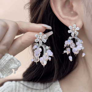 Close-up of a person wearing floral earrings with a blurred background