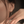 Close-up of a person wearing a delicate gold earring with a small diamond.