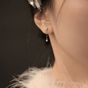 Close-up of a person wearing a silver earring with a dark background