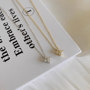 Two necklaces, one gold and one silver, on a white card with text.