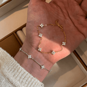 Gold and silver bracelet set on a hand with a neutral background