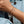 Close-up of a person's wrist wearing a delicate bracelet with colorful stones against a denim background.