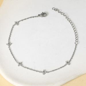 Silver bracelet with star-shaped charms on a white surface