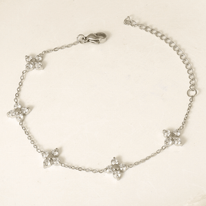 Silver bracelet with floral designs on a beige background