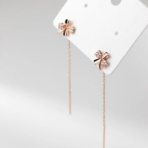 Rose gold butterfly earrings on a white card with a light gray background