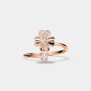 A gold-colored fidget spinner ring with a four leaf clover design and a small cubic zirconia stone.
