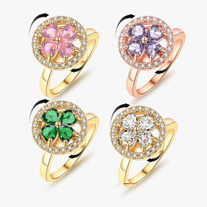 Four floral-themed rings with colorful gemstones on a white background