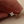 Gold ring with diamond flower design held between fingers against a neutral background