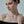 Woman wearing a delicate necklace against a neutral background