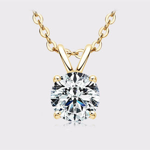 Gold necklace with a round diamond pendant on a light gray background