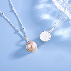 Pearl necklace with silver chain on a light blue background