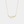 Gold necklace with leaf-like pendant on a light gray background