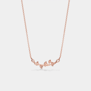 A gold-plated sterling silver necklace with a charm resembling a ginkgo leaf on a chain.