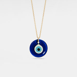 Blue evil eye pendant necklace on a gold chain against a white background