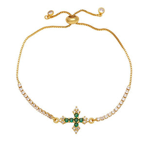 A gold-plated adjustable bracelet featuring a cross charm with cubic zirconia and small clear stones along the chain.