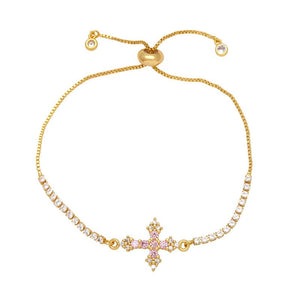 Gold bracelet with a cross charm on a white background