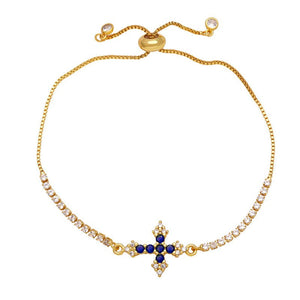 A gold-plated adjustable bracelet featuring a cross charm with cubic zirconia and small clear stones along the chain.