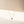 Gold necklace with a blue gemstone pendant on a beige background