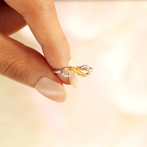 Gold and silver infinity ring on a blurred background