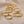 Gold rings with engraved numbers on a beige fabric background