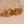 Four gold rings arranged in a row on a textured stone surface