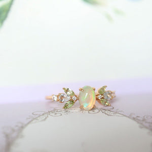 Gold ring with green gemstones on a decorative surface